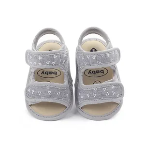 Top view detail of grey fabric baby sandals with white triangle pattern and straps