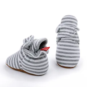 Vue détaillée de bottines d'hiver rayées pour bébé en gris et blanc avec doublure polaire.