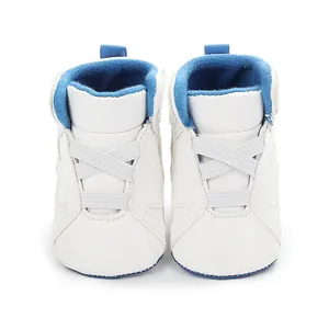 Front view detail of white infant basketball shoes with blue plush lining and soft sole
