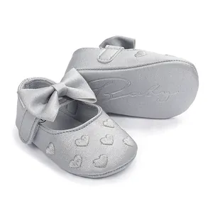 Detailansicht der silbernen Baby-Prinzessin-Schuhe mit Herzstickerei und Schleife.