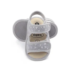 Grey baby walking sandals with soft soles and white triangle patterns for toddlers