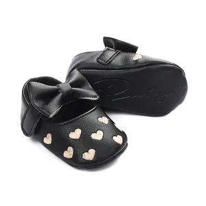 Detailansicht der schwarzen Baby-Prinzessinenschuhe mit Herzstickerei und Schleife