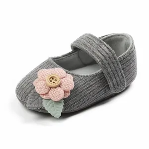 Weicher grauer Baby-Mädchen-Schuh aus Strick mit rosa Blume und dekorativem Holzknopf