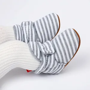 Gros plan de bottines d'hiver rayées gris pour bébé avec doublure polaire chaude
