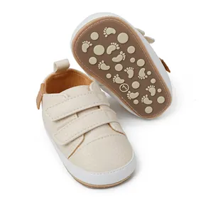 Close-up of cream baby walking shoes with velcro straps and anti-slip footprint sole