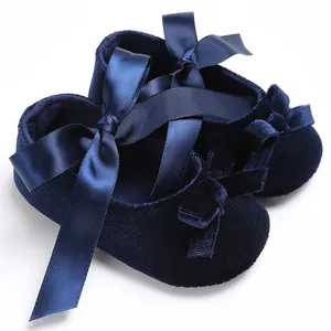 Gros plan détaillé de chaussures pour bébé en velours bleu marine avec ruban de satin