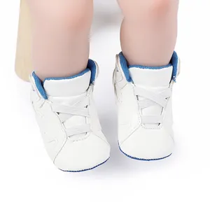 Close-up of white and blue infant basketball shoes with soft soles and elastic laces.