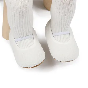 Detailopname van witte pluche baby wandelschoenen met elastische band om voetjes
