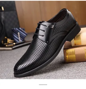 Gros plan de chaussures de ville en cuir noir ajouré et respirant avec des lacets.