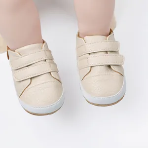Close-up detail of beige faux-leather baby walking shoes with velcro straps