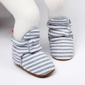 Gros plan sur les bottes d'hiver rayées pour bébé avec semelles souples et antidérapantes