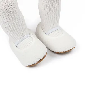 Close-up van witte pluizige babyschoentjes met zachte zool voor de winterperiode