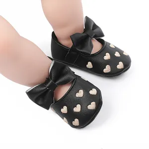 Detailansicht der schwarzen Baby-Prinzessin-Schuhe mit Goldherz-Stickerei und Zierschleife