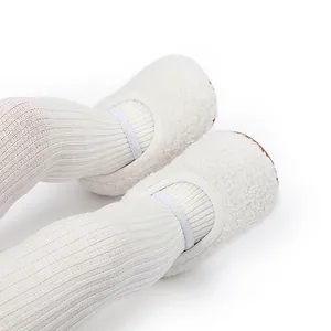Macrodetail van witte pluizige baby-winterschoenen met zachte zool en witte legging