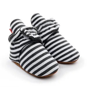 Gros plan de bottines d'hiver rayées pour bébé avec semelles souples et doublure