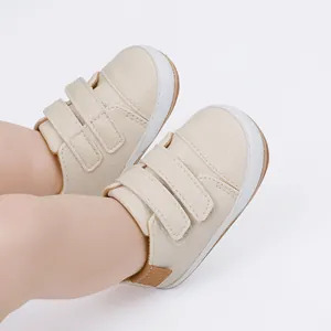 Close-up of cream baby walking shoes with dual Velcro straps for infant comfort