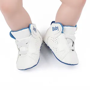 Close-up of white baby basketball walking shoes with soft soles and blue "Baby" embroidery.