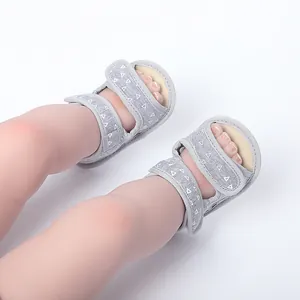Detailed view of grey patterned soft-sole non-slip baby summer sandals on feet