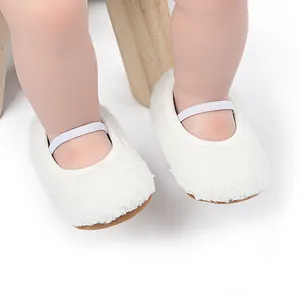 Detailopname van witte pluche baby loopschoentjes met elastische band voor grip.