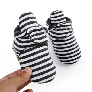Gros plan de bottines d'hiver pour bébé à rayures noires et blanches avec polaire