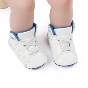 Close-up view of white and blue soft-sole baby basketball shoes for pre-walkers.