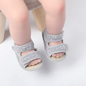 Detailed view of grey baby walking sandals with white triangle pattern and soft sole.