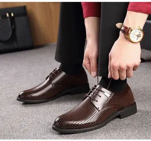 Détail d'un homme laçant des chaussures de ville marron foncé en cuir ajouré respirant