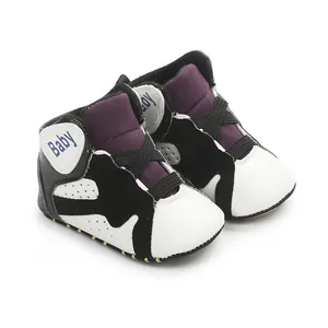 Detail shot of black and white high-top baby basketball shoes with purple accents.
