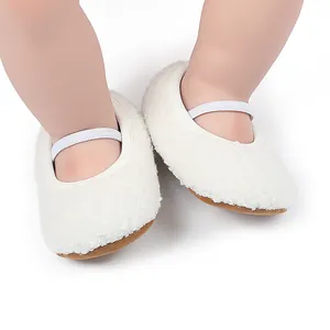 Detailed view of white fuzzy plush baby shoes with elastic strap and soft brown sole
