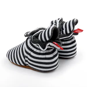 Vue détaillée de bottes d'hiver rayées pour bébé avec doublure polaire et semelle souple.