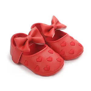 Detailansicht der roten Baby-Prinzessin-Schuhe mit eleganten Schleifen und Herzmustern