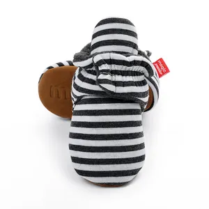 Gros plan de bottines bébé à rayures avec doublure en polaire et semelle souple