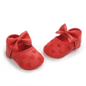 Nahaufnahme der roten Baby-Prinzessinenschuhe mit Schleife und Stickereidetails