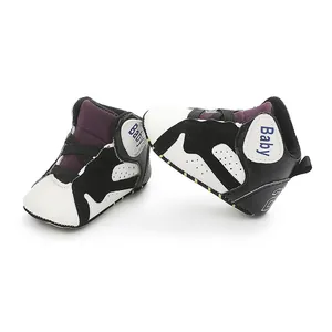 Detailed side view of black and white baby basketball shoes with soft anti-slip soles for infants