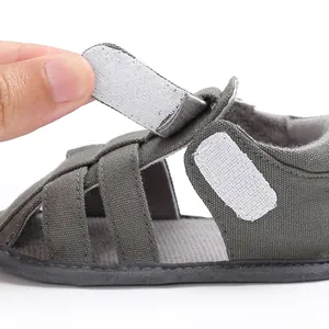 Close-up detail of adjustable hook-and-loop strap on baby boy soft sole closed-toe sandals