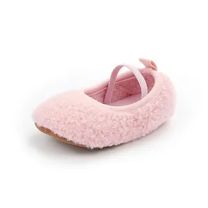 Side view detail of pink fuzzy baby walking shoes with elastic strap and soft sole