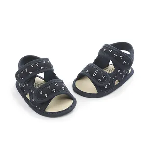 Detail of navy blue baby sandals with white triangle patterns and velcro straps.