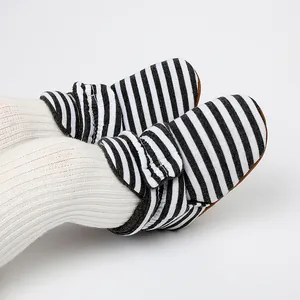 Gros plan de bottes d'hiver pour bébé à rayures noires et blanches avec doublure polaire