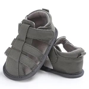 Detail view of grey closed-toe canvas infant sandals with adjustable strap