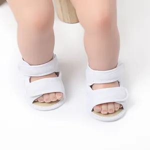 Close-up of white breathable mesh baby walking shoes with dual Velcro strap closures.