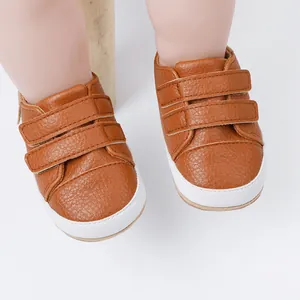Close-up of brown leather baby walker shoes with velcro straps and white soles