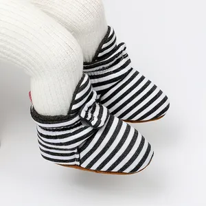 Gros plan de bottines rayées pour bébé avec doublure polaire et semelles souples