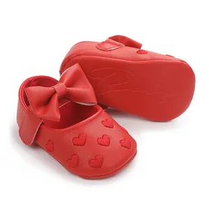 Detailaufnahme roter Lauflernschuhe für Kleinkinder mit Herzstickerei und weichem Schleifenband