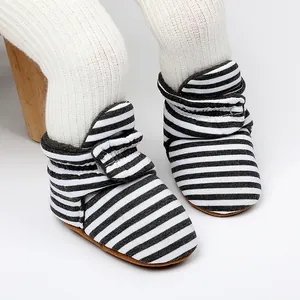 Gros plan de bottines de bébé rayées noir et blanc pour l'hiver, souples et chaudes