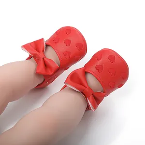 Detailansicht roter Baby-Prinzessinenschuhe mit Herzmuster und schicker Schleife