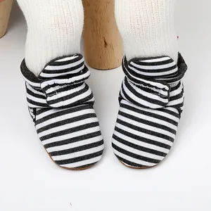 Gros plan de bottines de marche pour bébé à rayures noires et blanches avec velcro