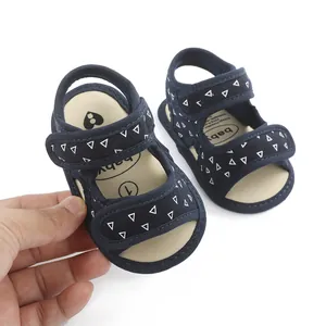 Macro view of navy blue baby sandals featuring triangle pattern and soft cream sole