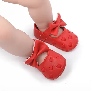 Detaillierte Ansicht roter Baby-Lauflernschuhe mit Herzstickerei und einer großen Schleife