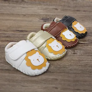 Vista detallada de zapatos de bebé con diseño de león y suelas de goma antideslizantes