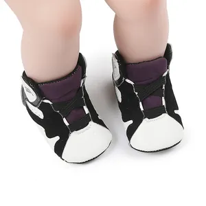 Close-up of black and white baby basketball shoes with soft non-slip soles on infant feet